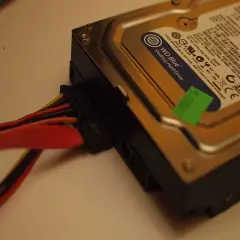 Jak podłączyć dysk HDD do komputera: widok na dysk WD Blue z podłączonymi kablami zasilania i SATA.