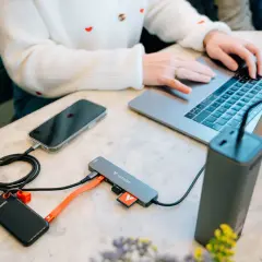 Przenośny dysk i telefon podłączone do laptopa przez hub, wykorzystując pełną **usb 3.2 speed** do szybkiego transferu danych.