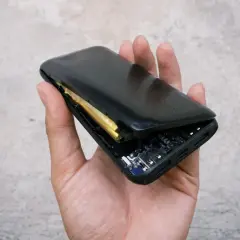 Uszkodzony powerbank z widoczną baterią i płytką drukowaną. Czy to problem z gwarancją na baterie w telefonie?
