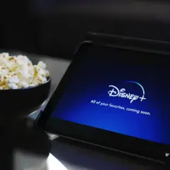 Tablet z logo Disney+ i miska popcornu. Idealne do wspólnego oglądania, nawet przy **disney+ dzielenie konta**.