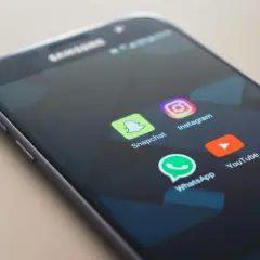 Ekran telefonu z ikonami aplikacji: Snapchat, Instagram, WhatsApp, YouTube. Dowiedz się, jak włączyć aplikacje w tle Android.