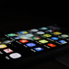 Ekran smartfona z ikonami aplikacji, takimi jak Phone, Contacts, Messages, Sparkasse, Music, Snapchat, YouTube. Dowiedz się, jak odinstalować aplikacje.