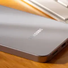 Srebrny telefon Samsung leży obok klawiatury. Jego bateria adaptacyjna zapewnia długie działanie.