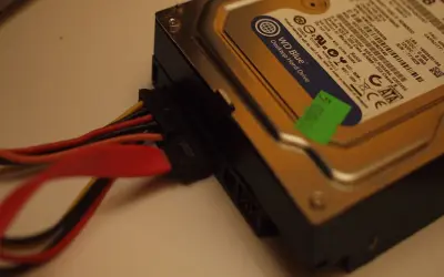 Jak podłączyć dysk HDD do komputera: widok na dysk WD Blue z podłączonymi kablami zasilania i SATA.