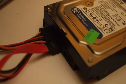Jak podłączyć dysk HDD do komputera: widok na dysk WD Blue z podłączonymi kablami zasilania i SATA.