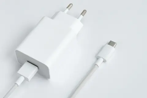 Biała ładowarka sieciowa z kablem USB-C. Dowiedz się, jak obliczyć moc ładowarki, by wybrać najlepszą dla swojego urządzenia.