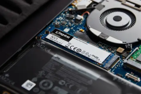 Dysk SSD NVMe M.2 Kingston NV1, gdzie jest dysk w komputerze, zamontowany obok baterii i wentylatora.