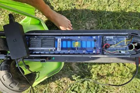 Otwarta bateria hulajnogi Xiaomi, podłączona ładowarka. Może to być powód, dla którego telefon się nie ładuje Xiaomi.