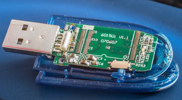 Rozłożony pendrive z widoczną zieloną płytką drukowaną i złączem USB. Płytka zawiera oznaczenia, np. "6015U1 V1.1". To wszystko, co potrzebne, by zrozumieć, **fat32 co to** jest za system plików.