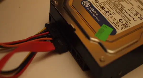 Jak podłączyć dysk HDD do komputera: widok na dysk WD Blue z podłączonymi kablami zasilania i SATA.