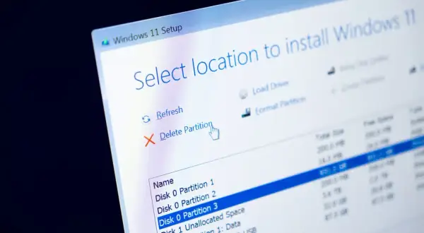Instalator Windows 11 pokazuje opcje zarządzania partycjami, w tym usuwanie i formatowanie dysku systemowego.