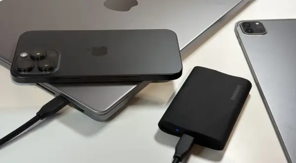 Jak podłączyć dysk zewnętrzny do telefonu? Na zdjęciu iPhone, iPad i MacBook, a także dysk Samsung.