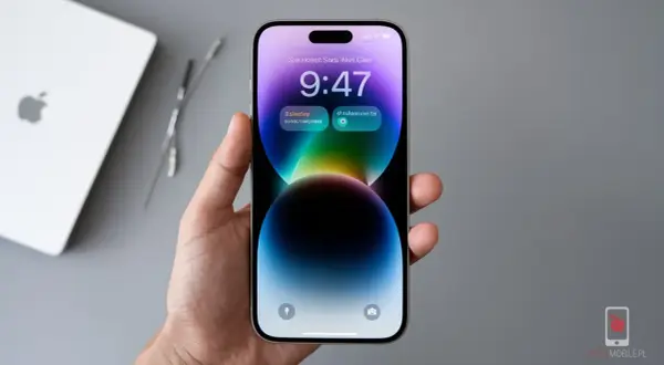 Dłoń trzyma iPhone 14 z kolorową tapetą i widoczną godziną 9:47. Ekran odświeżanie jest płynne.
