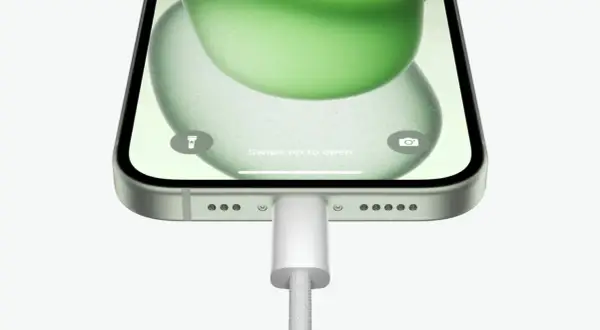 iPhone z zieloną tapetą, podłączony do ładowania. Możliwość powershare iPhone.