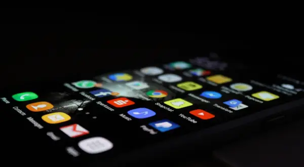 Ekran smartfona z ikonami aplikacji, takimi jak Phone, Contacts, Messages, Sparkasse, Music, Snapchat, YouTube. Dowiedz się, jak odinstalować aplikacje.