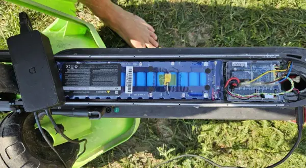 Otwarta bateria hulajnogi Xiaomi, podłączona ładowarka. Może to być powód, dla którego telefon się nie ładuje Xiaomi.