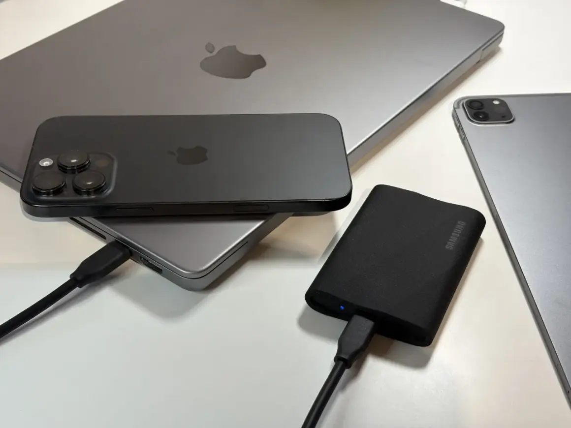Jak podłączyć dysk zewnętrzny do telefonu? Na zdjęciu iPhone, iPad i MacBook, a także dysk Samsung.