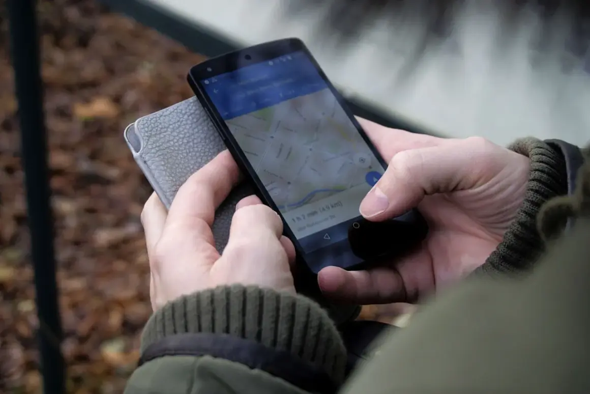 Osoba sprawdza na telefonie, jak zrobić wizytówkę w telefonie, korzystając z mapy.