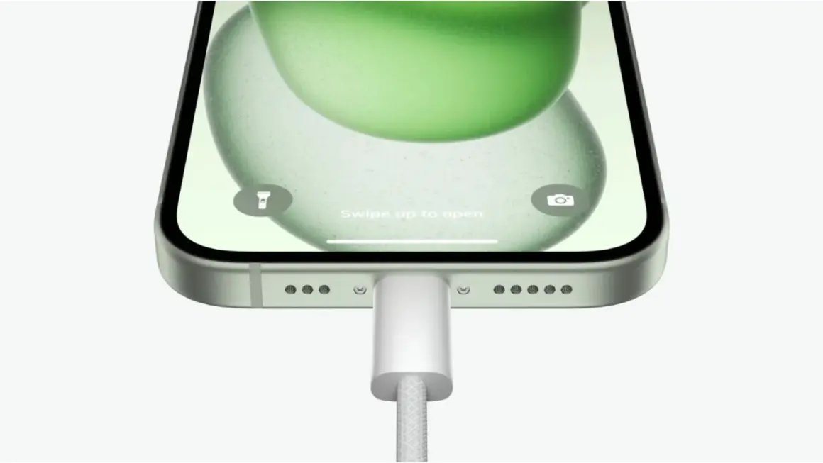 iPhone z zieloną tapetą, podłączony do ładowania. Możliwość powershare iPhone.