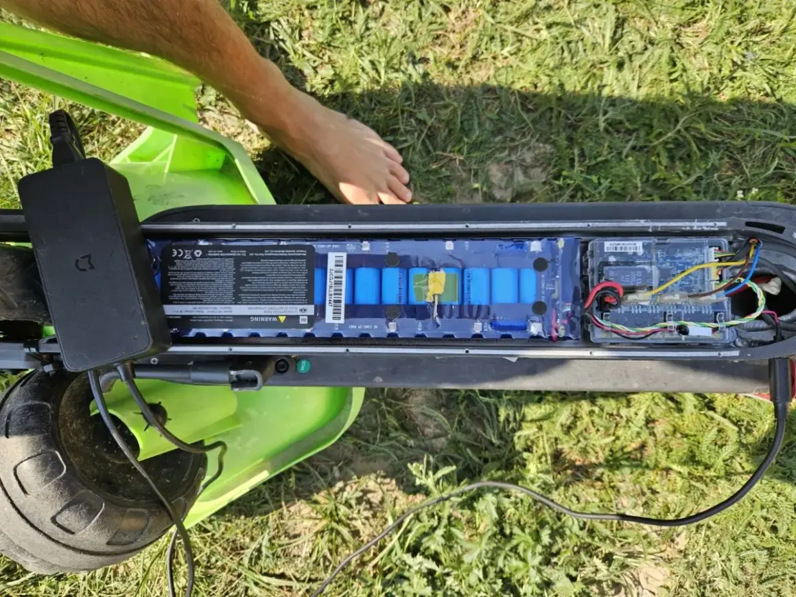 Otwarta bateria hulajnogi Xiaomi, podłączona ładowarka. Może to być powód, dla którego telefon się nie ładuje Xiaomi.