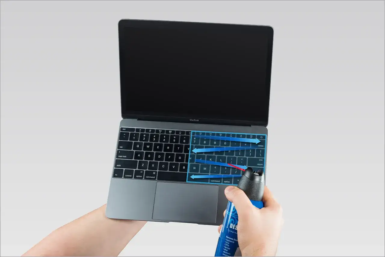 Jak wyczyścić Maca? Użyj sprężonego powietrza, aby usunąć kurz z klawiatury MacBooka, kierując strumień zgodnie ze strzałkami.