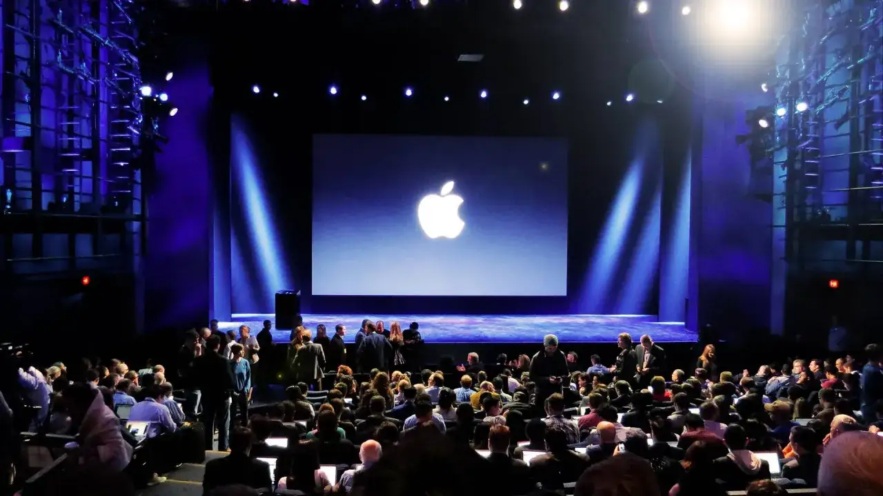 Widownia czeka na premierę iPhone'a. Na scenie logo Apple.