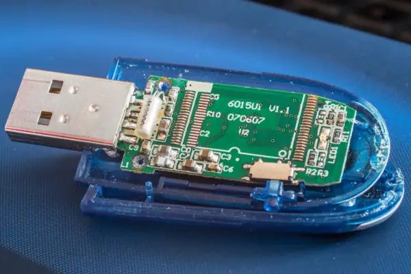 Rozłożony pendrive z widoczną zieloną płytką drukowaną i złączem USB. Płytka zawiera oznaczenia, np. "6015U1 V1.1". To wszystko, co potrzebne, by zrozumieć, **fat32 co to** jest za system plików.