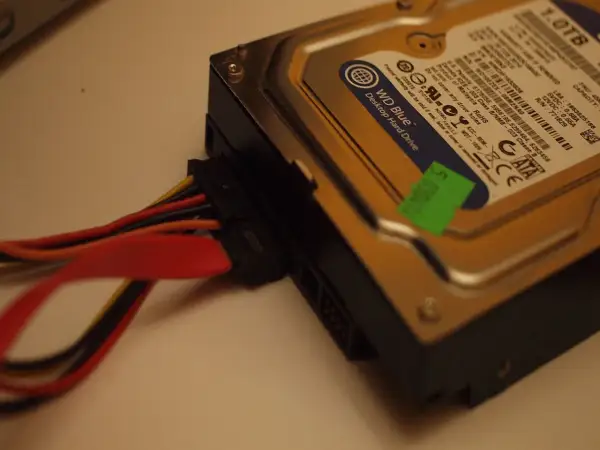 Jak podłączyć dysk HDD do komputera: widok na dysk WD Blue z podłączonymi kablami zasilania i SATA.