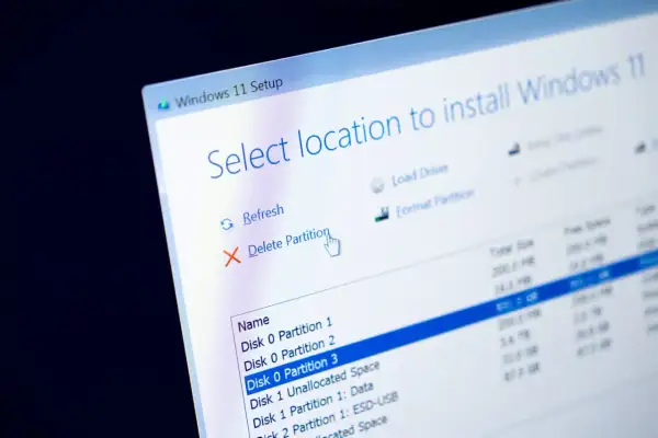 Instalator Windows 11 pokazuje opcje zarządzania partycjami, w tym usuwanie i formatowanie dysku systemowego.