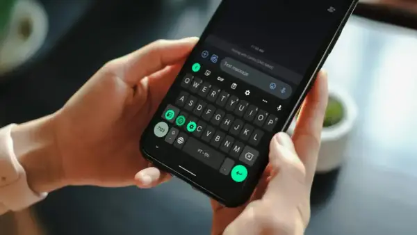 Dłonie trzymają smartfon z klawiaturą. Wpisuję wiadomość, odkrywając historię schowka.