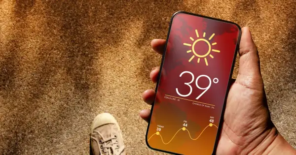 Dłoń trzyma telefon z prognozą pogody: 39 stopni, upał. Czy to już throttling?